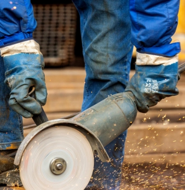 Man cutting into metal material with sparks flying